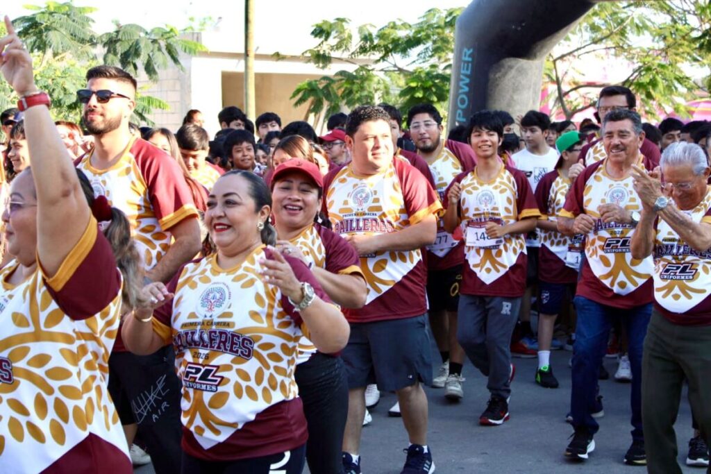 El alcalde Edwin Bojórquez cruzando la meta junto a estudiantes en la carrera Bailleres